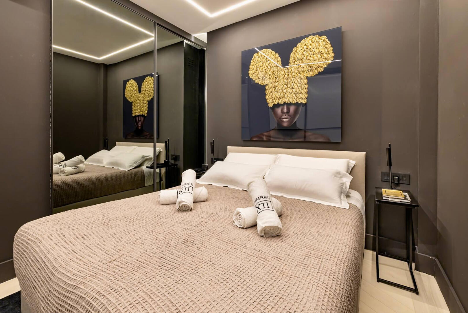 Elegant bedroom with calming tones, custom pillows, and soft lighting for peaceful rest.